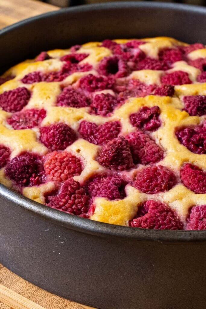 side shot of summer raspberry cake still in the pan after cooking
