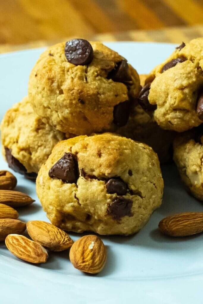 almond flour oat chocolate chip cookies on a white plate next to almonds