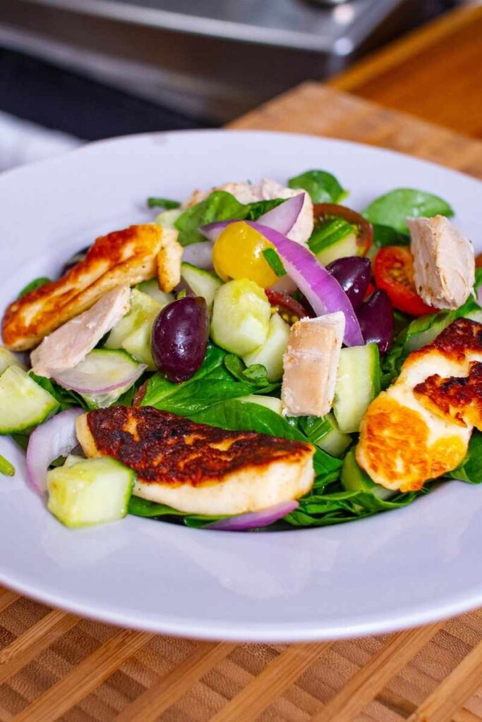 chicken halloumi salad plated in a white bowl