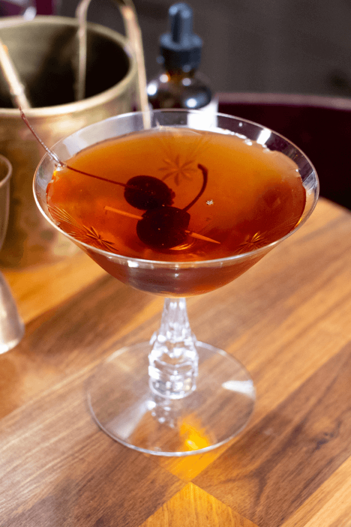 manhattan with rye garnished with cherries on toothpicks