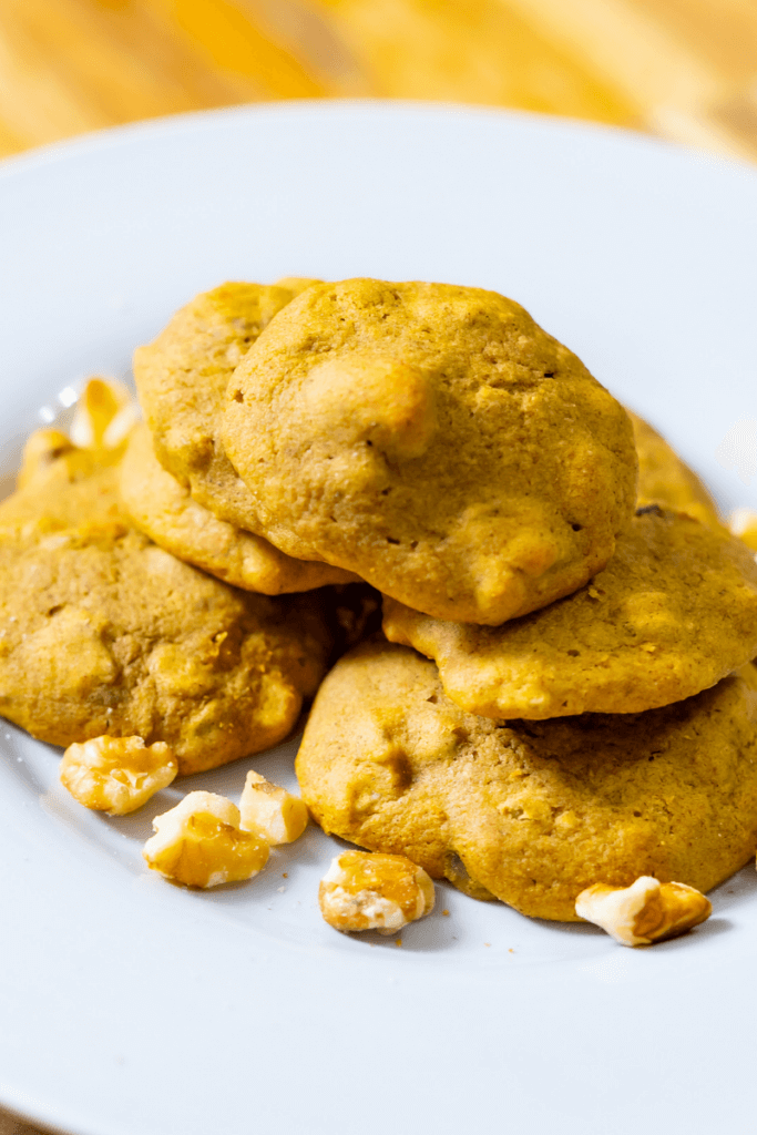 butternut cookies on small white plate next to walnuts