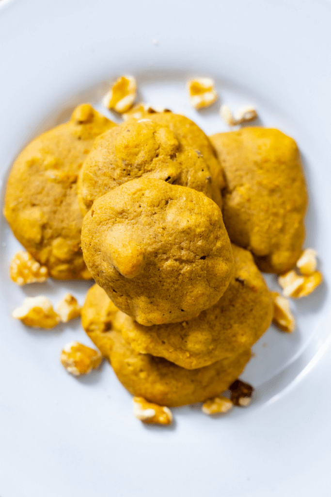 top shot of a stack of butternut cookies next to chopped walnuts
