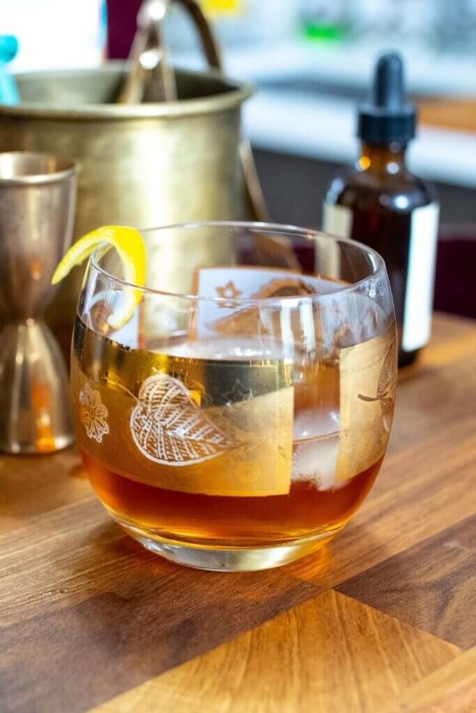 side shot of honey old fashioned with lemon twist as a garnish