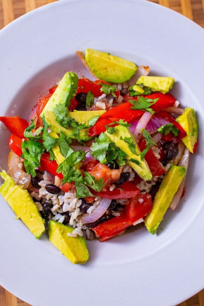 top shot of vegan fajita bowl garnished with cilantro and avocado