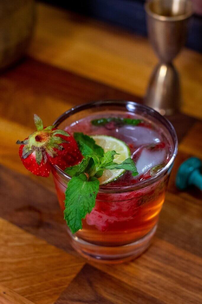 tom collins with lime in a small glass