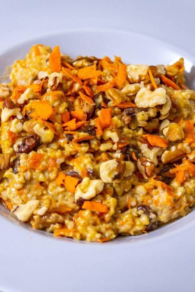a bowl full of carrot cake oat porridge with walnuts on top