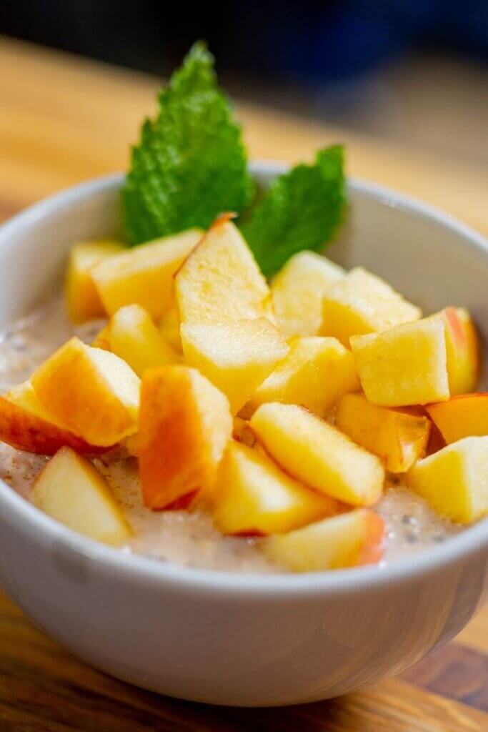 cinnamon overnight oats in a white bowl with apples on top