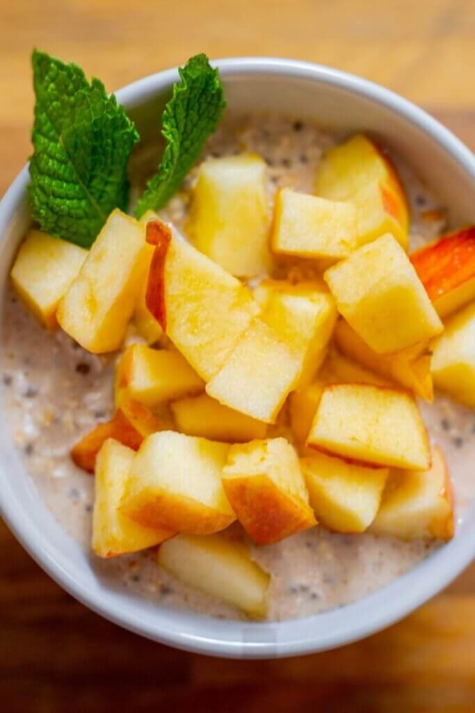 top shot of overnight cinnamon oats with diced apples in a white bowl