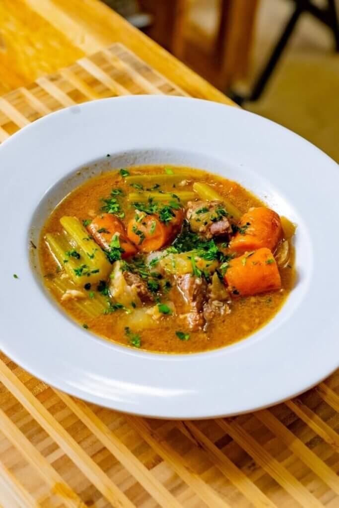 a bowl of beer braised short ribs with veggies on the counter