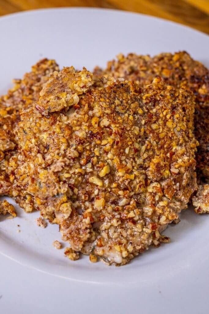 pecan crusted pork chops on a white plate