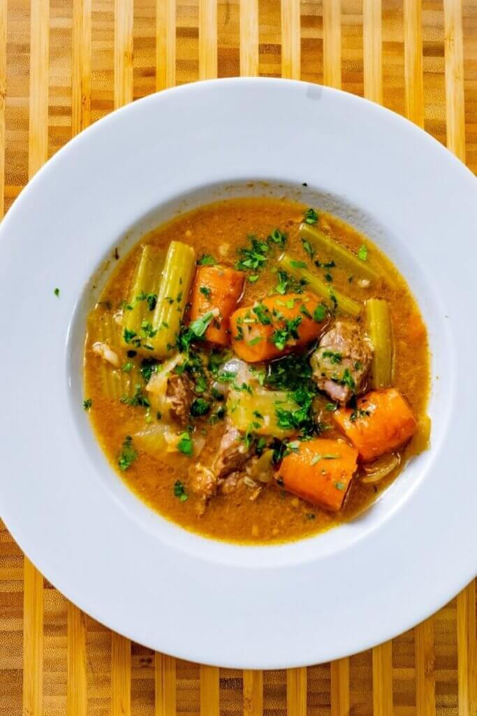 top view of beer braised short ribs in a large white bowl