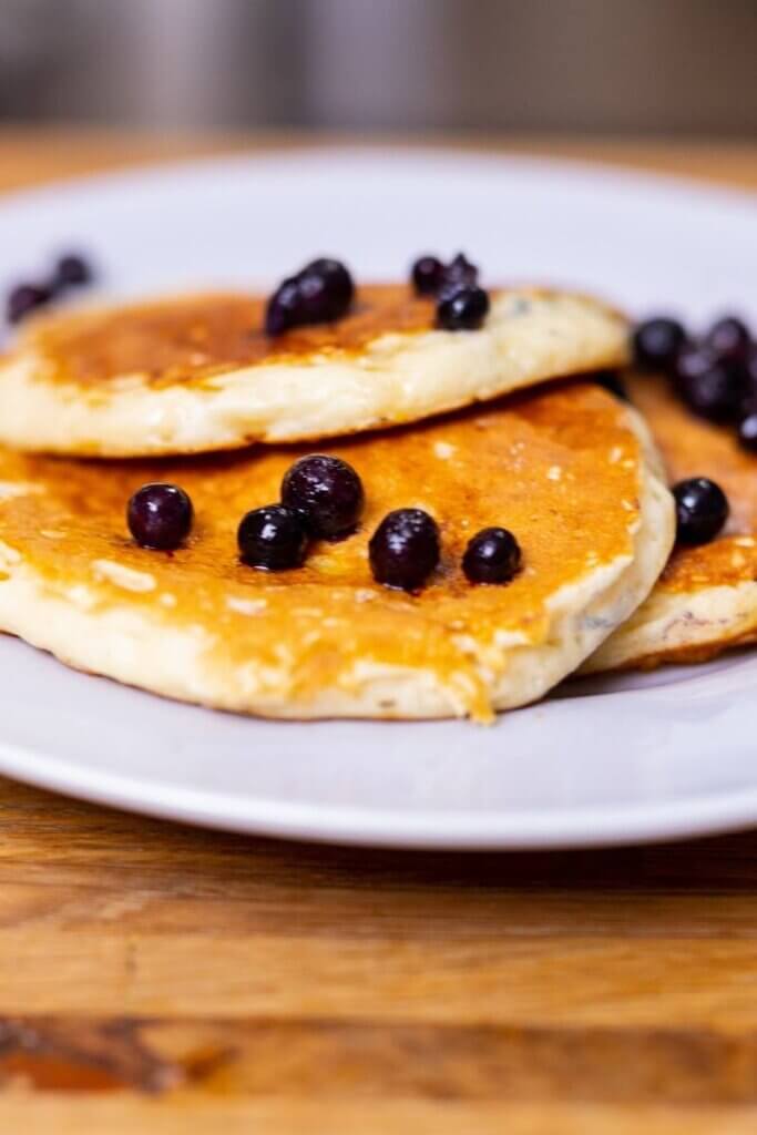 oat milk pancakes on a white plate with blueberries