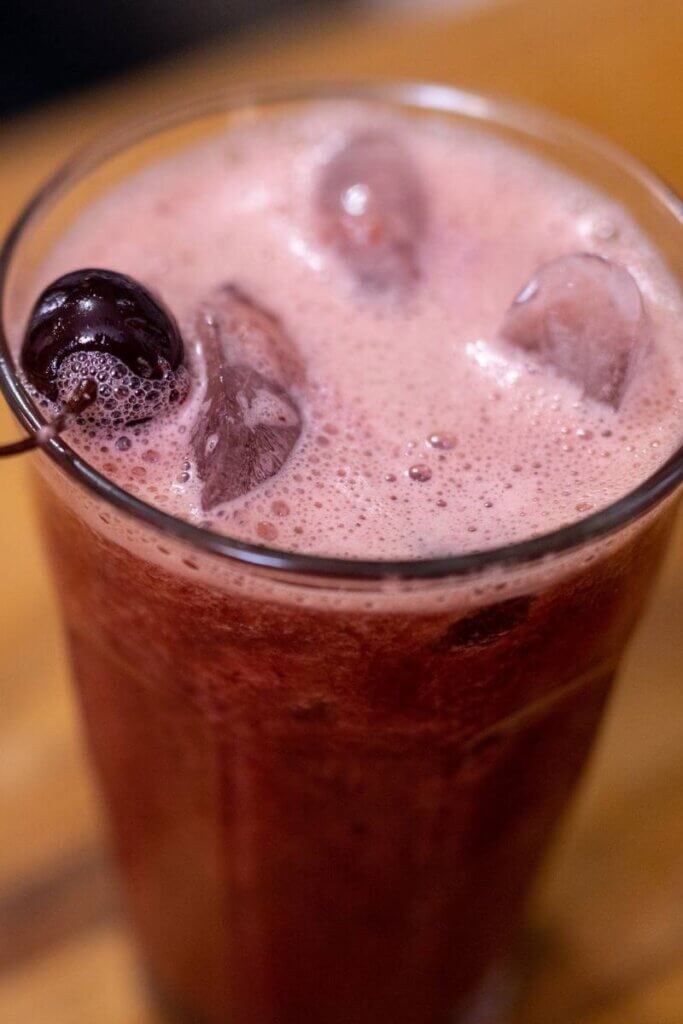 close up of a blended cherry cooler topped with a cherry
