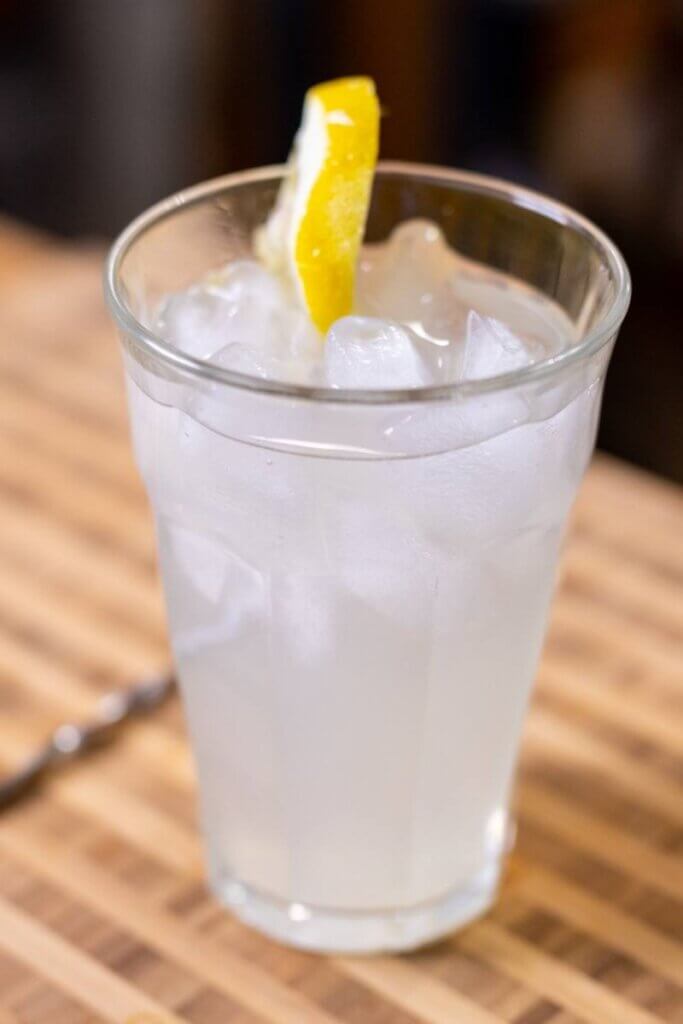 homemade paloma lemonade in a glass with a lemon for garnish