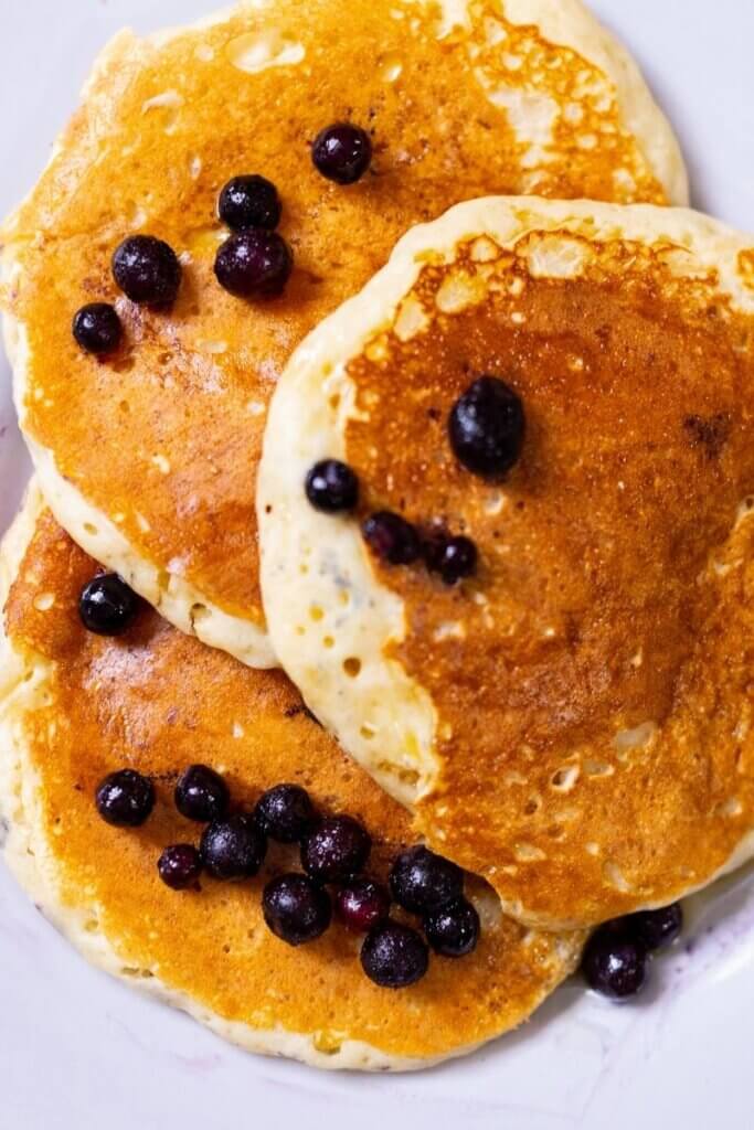 top shot of three oat milk pancakes with blueberries