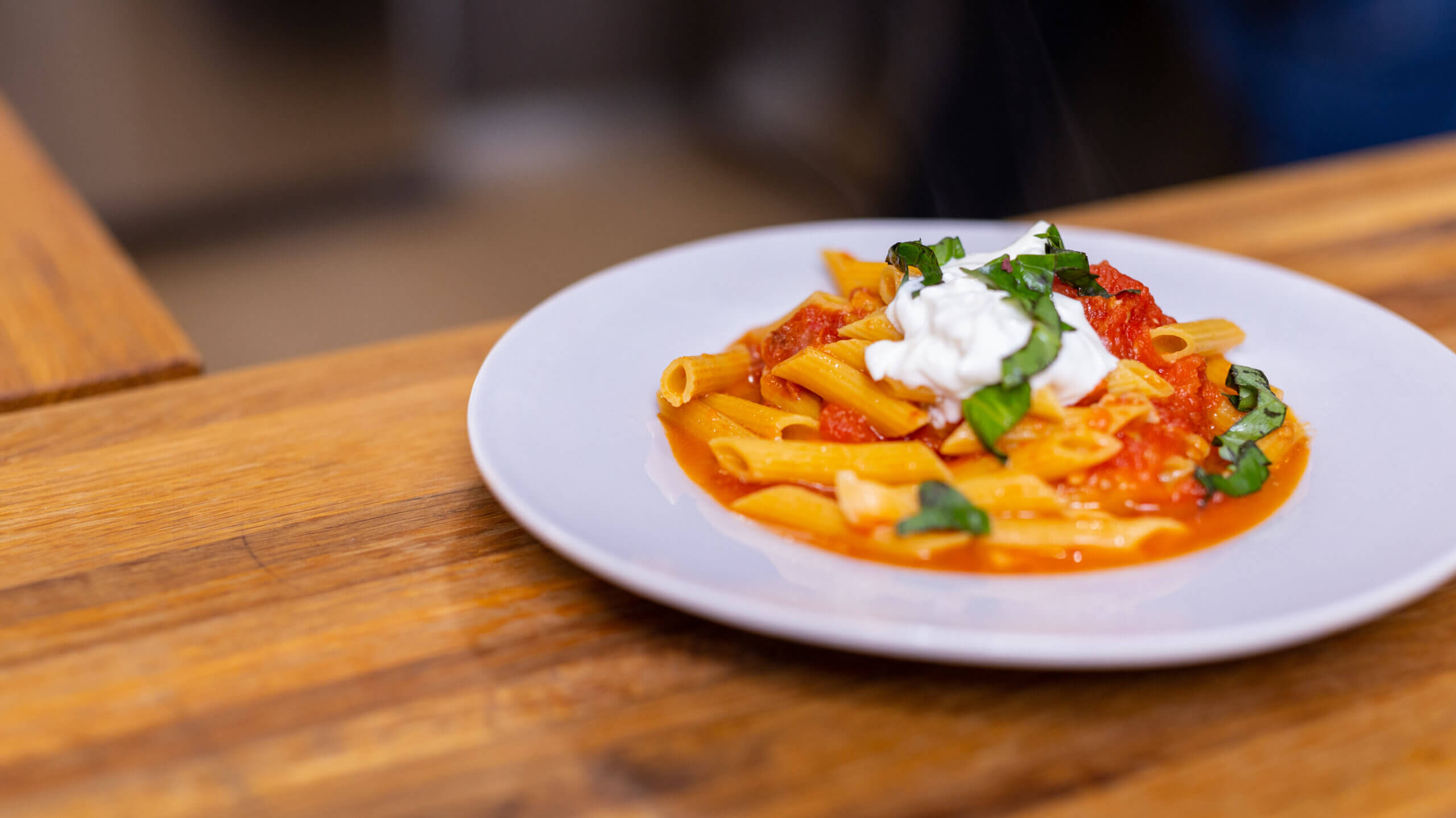 pasta pomodoro with burrata in large white bowl