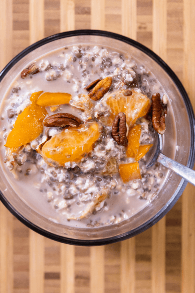 top view of chocolate orange overnight oats in a glass bowl topped with orange slices