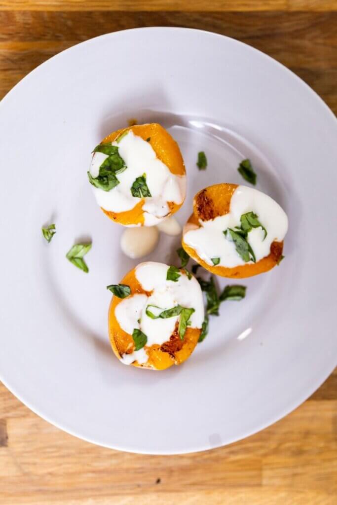 three glazed apricots on a white plate