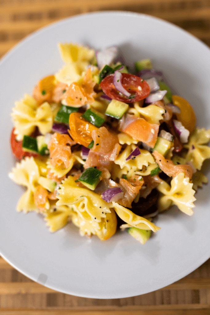 top view of smoked salmon pasta salad in a large white bowl.