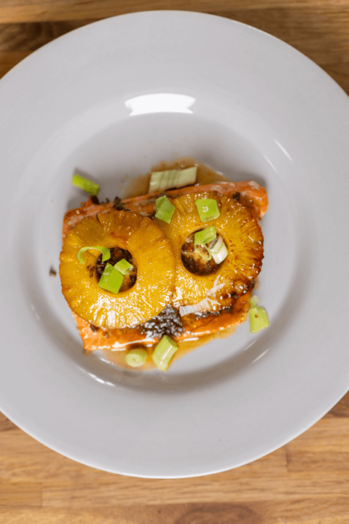  top view on honey jerk salmon topped with rings of pineapple.