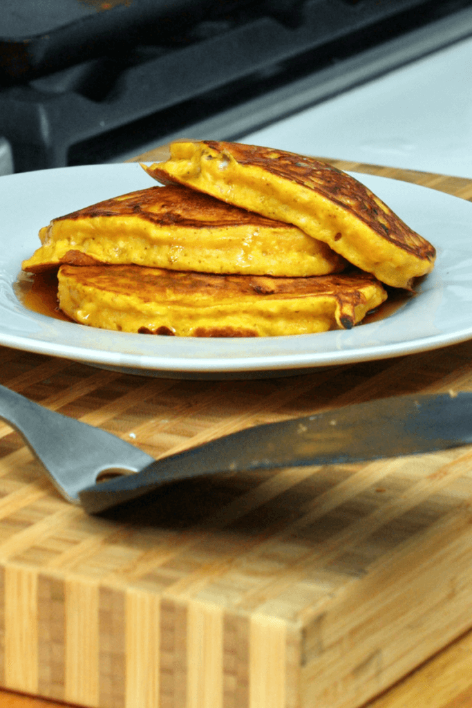 A stack of three fluffy cottage cheese pumpkin pancakes.