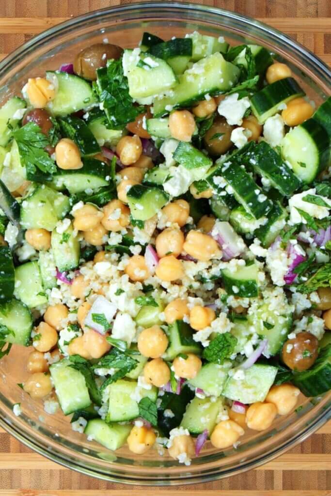 A large glass bowl of millet salad.