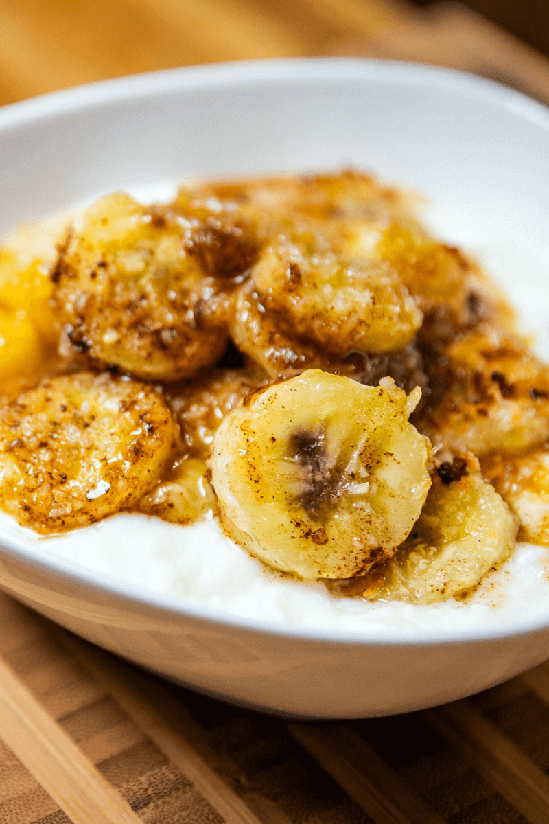 Baked bananas in a small white bowl.