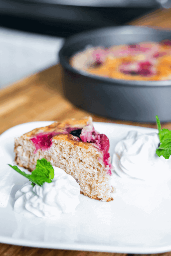 Slice of sour cherry cakes on a plate with whipped cream.