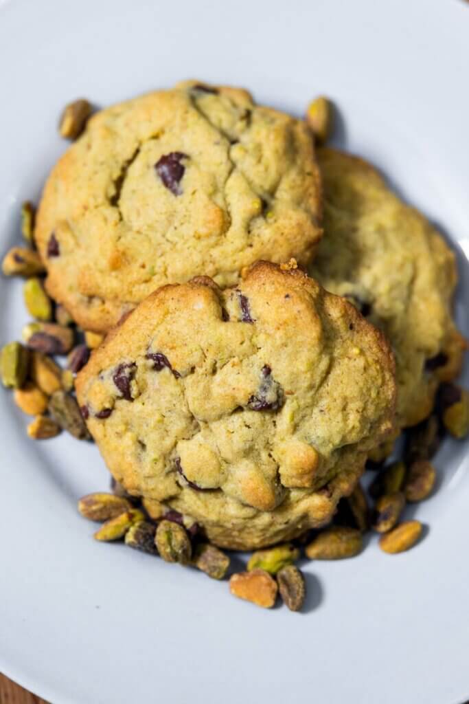 A stack of pistachio chocolate chip cookies on a plate.